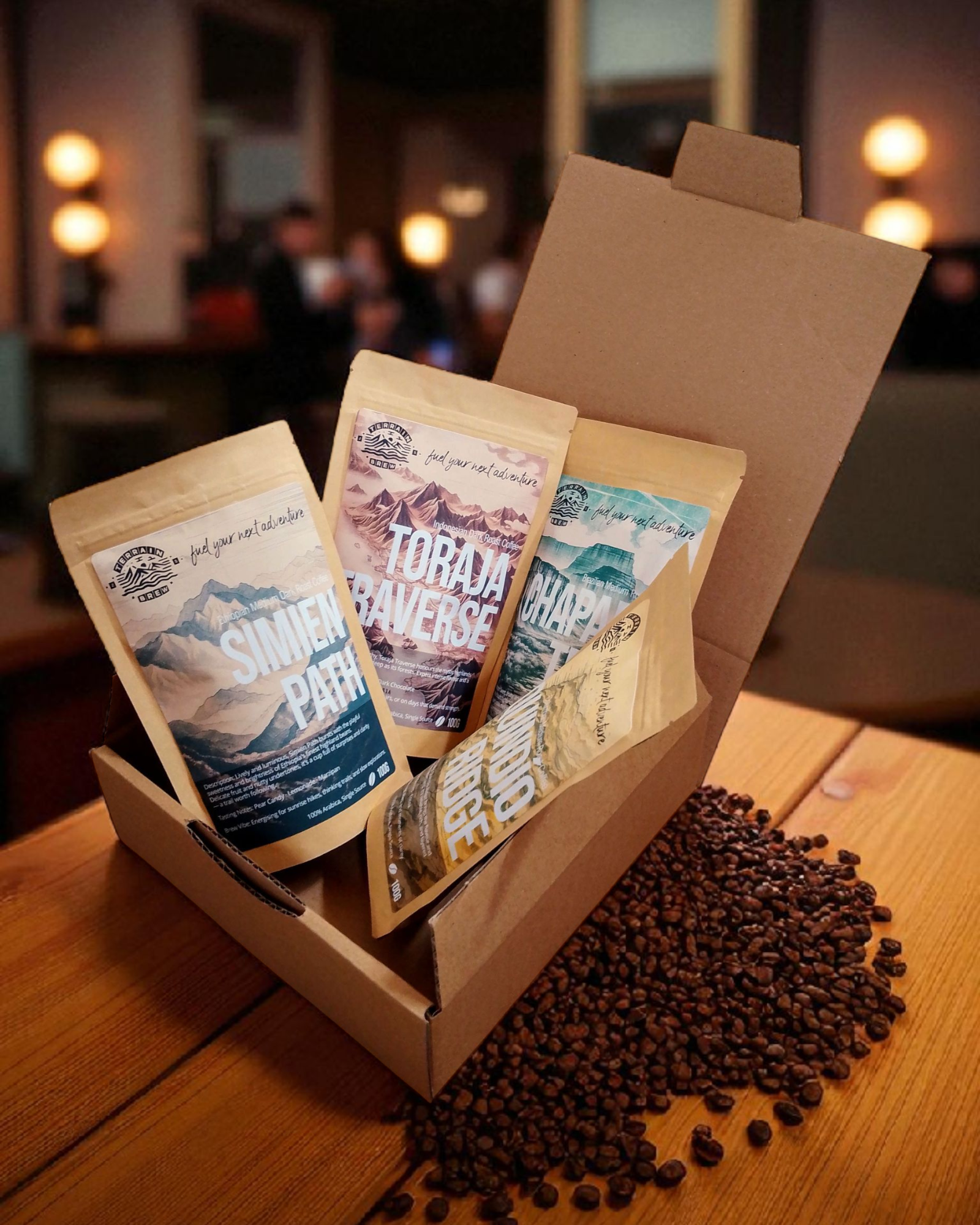 Terrain Trail Collection in a cardboard box on a table with coffee beans